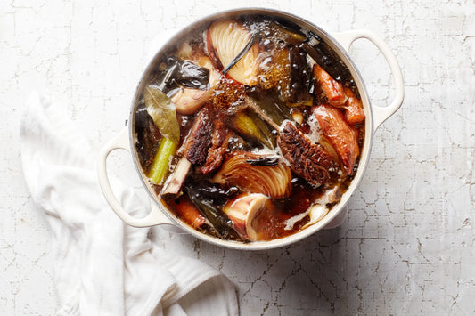 Bone broth base simmering with beef soup bones, carrots, celery and onions.