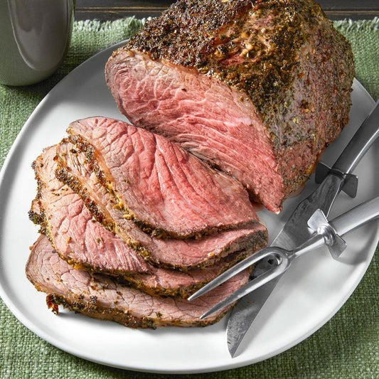 Herb crusted top round roast with golden brown curst and tender pink inside