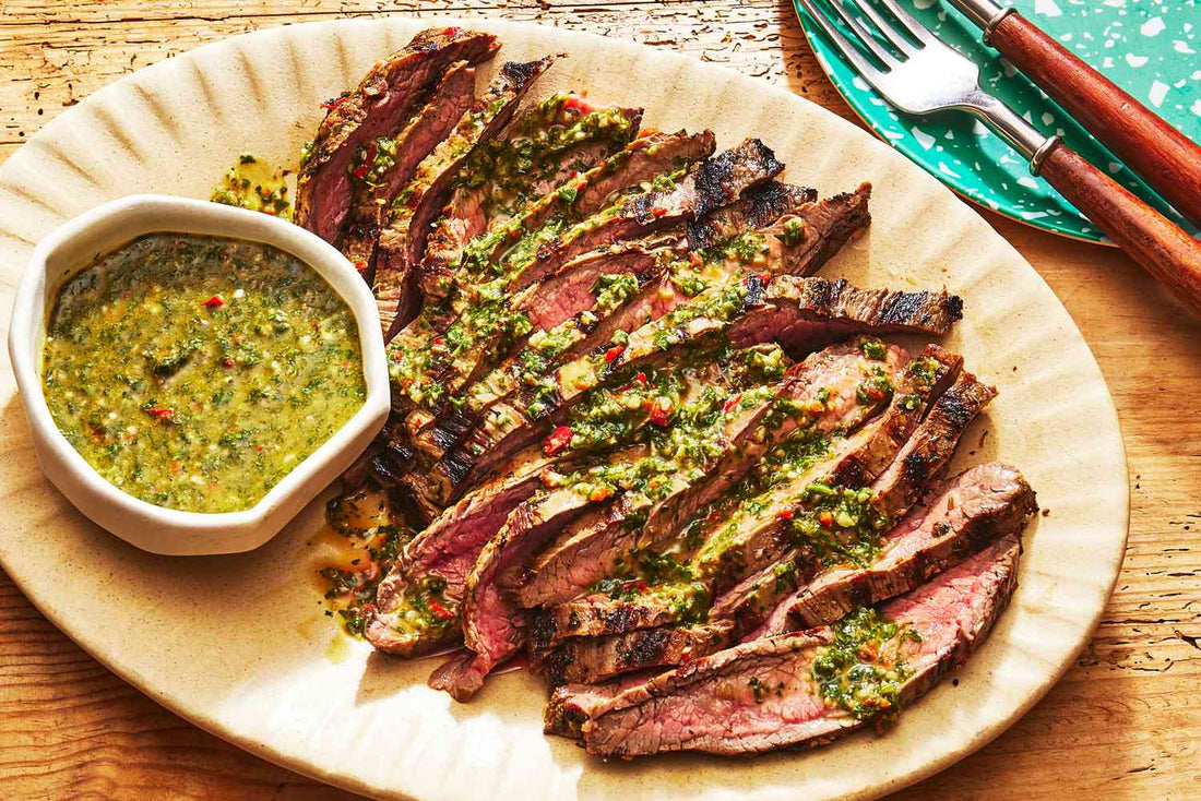 Grilled flank steak topped with chimichurri sauce and fresh herbs