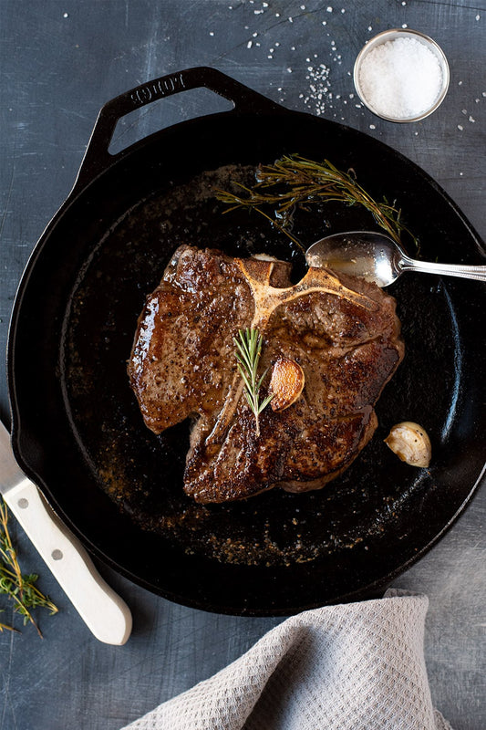 Cast iron seared T-bone steak with herb and garlic butter.